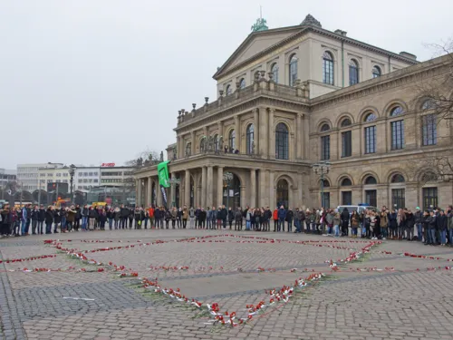 Schülerinnen und Schüler rund um einen großen Davidstern aus Blumen.