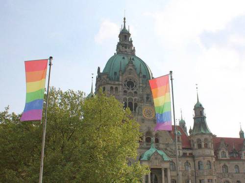 Regenbogen-Flaggen vor einem Gebäude. 