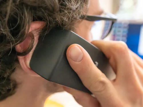 Ein Mann h&auml;lt sich einen Telefonh&ouml;rer ans Ohr