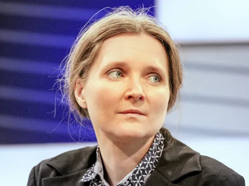 Portrait einer Frau vor einem blau-grauen Hintergrund