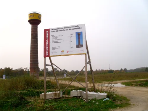 Conti-Schornstein mit Wasserbeh&auml;lter, im Bildvordergrund ein Bauschild 