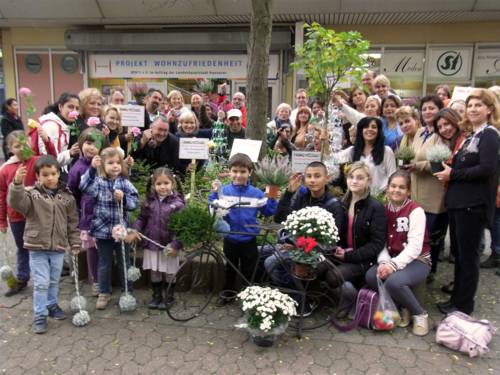 Ein große Anzahl Bewohnerinnen und Bewohner verschiedenen Alters aus dem Sahlkamps halten auf dem Gruppenfoto Pflanzen in den Händen.