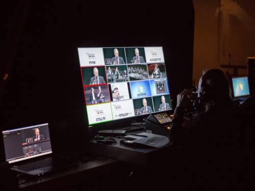 Symbolbild für ein LiveStream. Ein Bildregisseur sitzt vor einem großen Monitor und stellt die Livebilder der Übertragung zusammen.