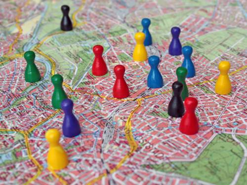 Symbolbild: Verschiedenfarbige Spielfiguren stehen auf dem Stadtplan von Hannover.