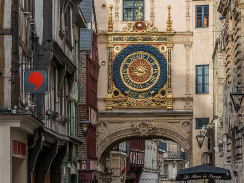 Eine übergroße, reich verzierte antike Wanduhr an einem alten Haus in Rouen