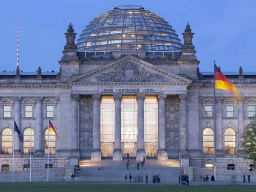Blick vom Platz der Republik zum Westportal des Reichstagsgebäudes während der Dämmerung.