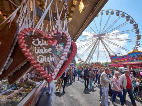 Menschen - auf dem Schützplatz flanierend, im Vordergrund ein Verkaufsstand mit Lebkuchenherzen.