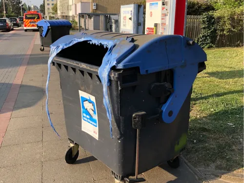 Altpapier in einer Mülltonne brennt