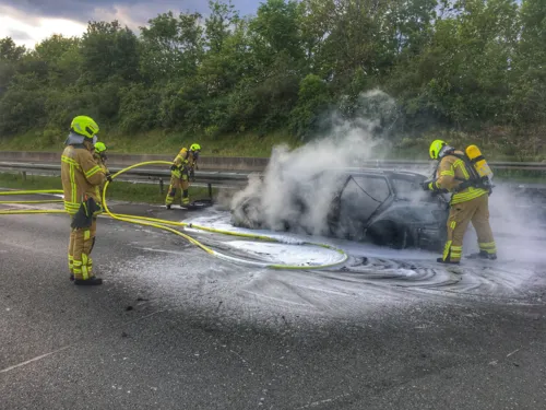 Löscharbeiten an einem Fahrzeugwrack