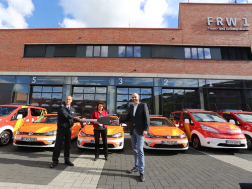 Personen stehen vor Fahrzeugen der Feuerwehr Hannover