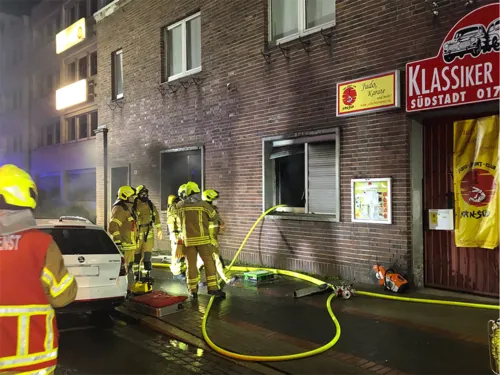 Feuerwehrleute vor einem verrauchten Fenster