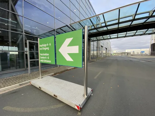 Hinweisschild für Impfzüge vor der Messehalle 25