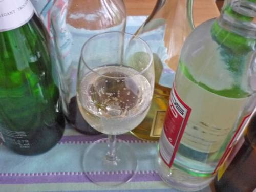 Diverse Flaschen Alkohol und davor ein halb geleertes Weinglas