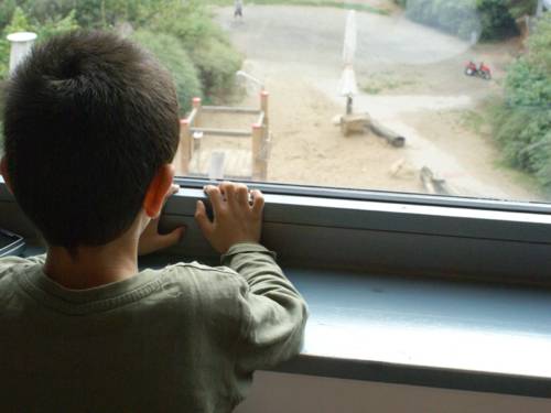 Ein Junge steht am Fenster 