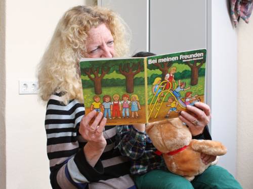 Eine Frau liest einem Kind aus einem Buch vor