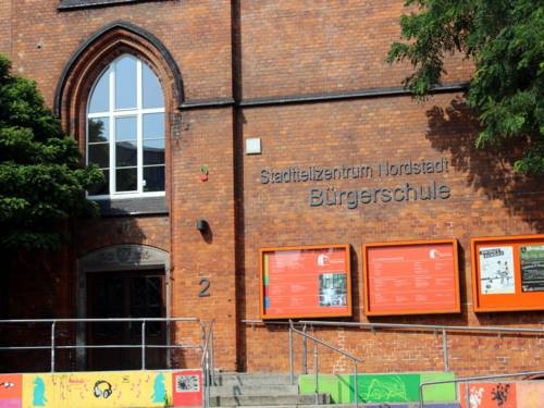 Backsteingebäude am Sprengel-Gelände. Rechts vom Eingang steht ein Schriftzug, auf dem steht: "Stadtteilzentrum Nordstadt Bürgerschule"
