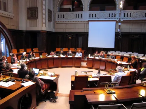 Die Ausschussmitglieder sitzen kreisförmig hinter Pulten im Hodlersaal. Einige Plätze sind unbesetzt.