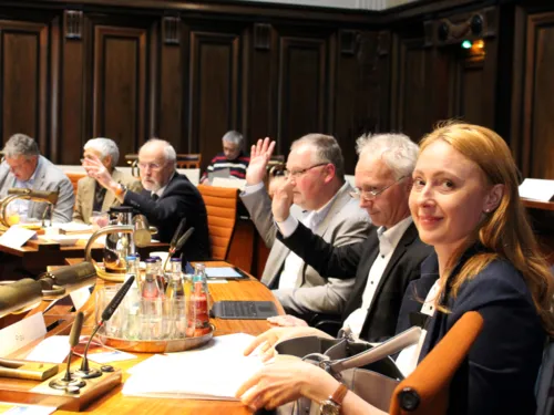 Sechs Personen sitzen nebeneinander an Pulten im Hodlersaal. Drei davon heben die Hand zur Abstimmung.