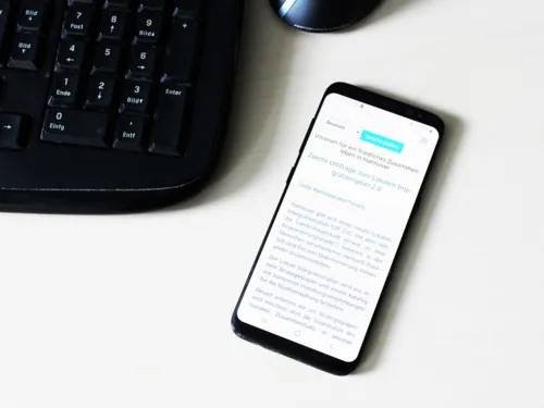 Symbolbild eines Smartphones, auf dessen Display die Startseite der Befragung angezeigt wird.