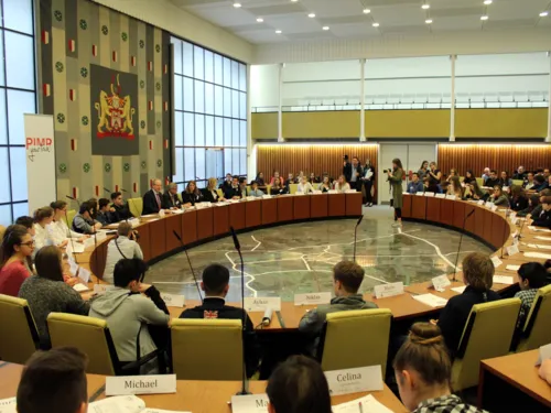 Etwa 100 Personen sitzen im Ratssaal hinter Pulten.