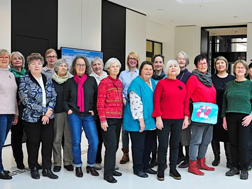 Gruppenfoto mit zw&ouml;lf freundlich l&auml;chelnden Frauen unterschiedlichen Alters 