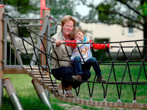 Eine Frau mit einem Mädchen auf einer Hängebrücke auf einem Spielplatz