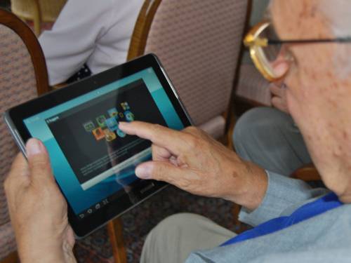 Ein älterer Herr verwendet einen Tablet-PC