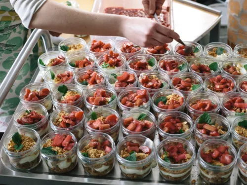Viele Dessertportionen im Glas, die mit roten Früchten bedeckt sind
