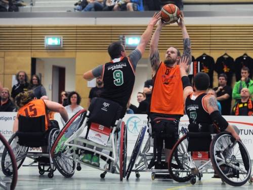 Beim Rollstuhlbasketball kämpfen vier Spieler um den Ball.