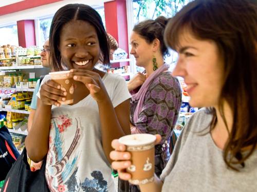 Zwei junge Frauen in einem Geschäft trinken fair gehandelten Kaffee