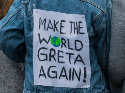 Eine Person von hinten, die eine Jeansjacke steht. Darauf steht "Make the world Greta again". 