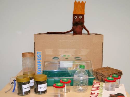 Gläser, Anzuchtbehälter, Broschüre und eine Puppe gehören unter anderem zum Unterrichtsangebot "Aktivkiste Kompost".
