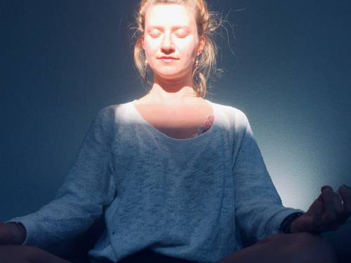 Eine meditierende Frau im Schneidersitz