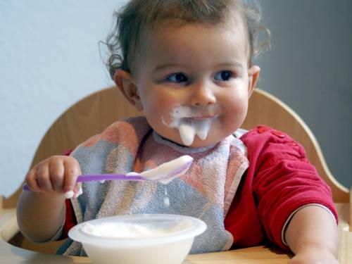 Ein kleines Kind isst Brei.