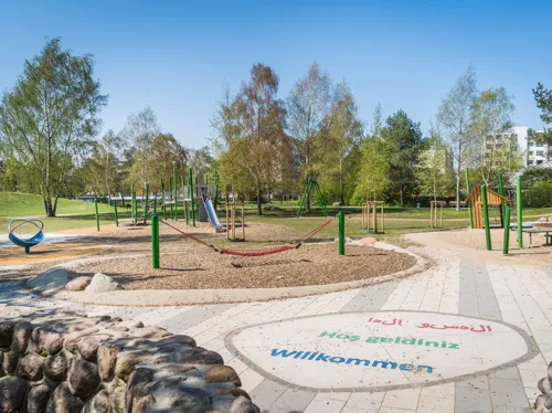 Ein Stadtteilpark mit Spielgeräten. 