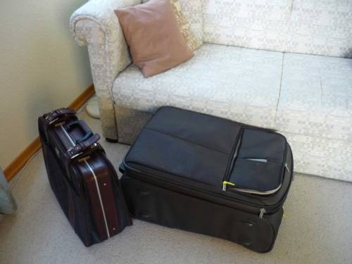 Zwei Koffer neben einem Sofa zeugen von der Ankunft von Gästen