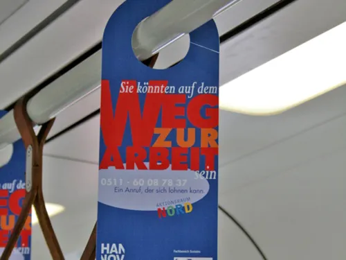 Ein Hängeschild in der U-Bahn mit der Aufschrift "Sie könnten auf dem Weg zur Arbeit sein"