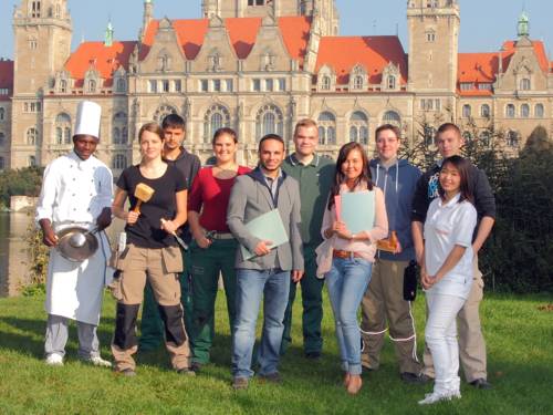 Zehn Auszubildende - zum Teil in Berufsbekleidung - vor dem Hannoverschen Rathaus 