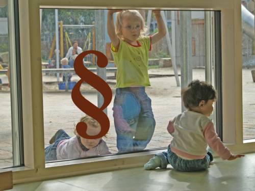 Kinder in einer Kindertagesstätte - davor ein Paragraphen-Zeichen als Symbol für Gesetze und Richtlinien.