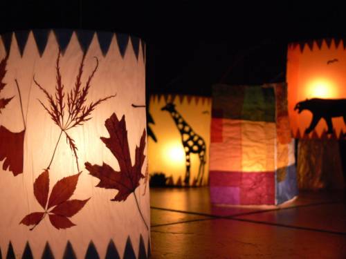 Vier Laternen mit Blätter- und Tiermotiven.