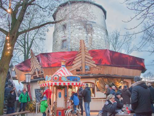 Weihnachtlich geschmückter Turm mit Kinderkarussell davor.
