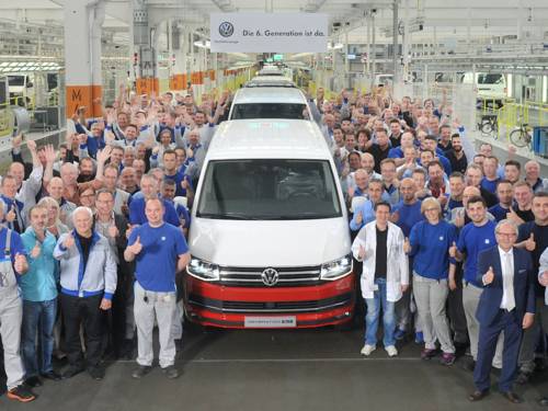 Menschen mit VW-Transporter in Produktionshalle 