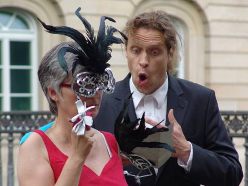 Mann singt zu einer Frau mit Maske.