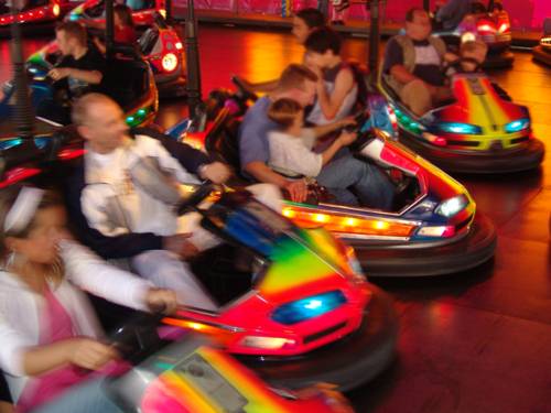 Erwachsene und Kinder in einem Fahrgeschäft