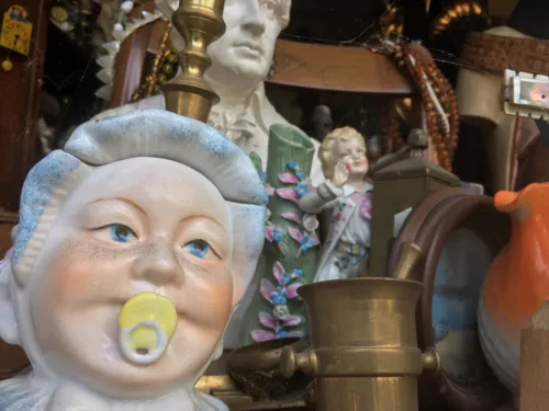 Mehrere alte Gegenstände, im Vordergrund eine Porzellanpuppe