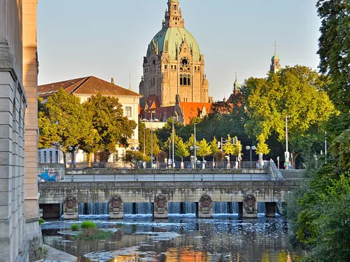 Autobrücke über Gewässer mit historischem Gebäude mit Kuppeldach im Hintergrund.