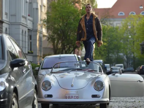 Mann steht in einem Cabriolet.