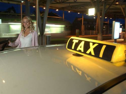 Frau, die in ein Taxi steigt.