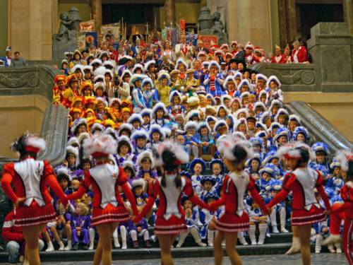 Viele Menschen in Karnevalsuniformen auf einer großen Treppe.