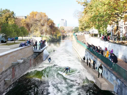 Grafik, die Surfer in einem Fluss auf k&uuml;nstlich erzeugter Welle zeigt.